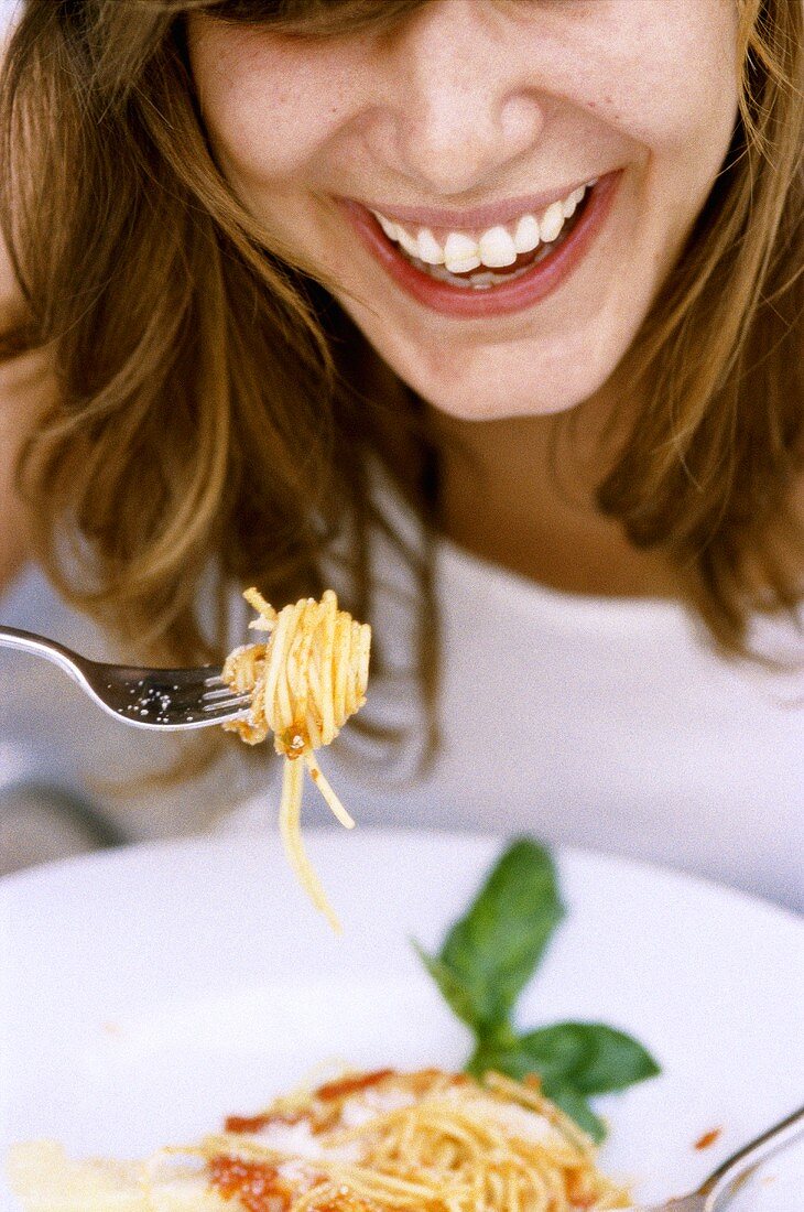 Frau isst Spaghetti mit Tomatensauce