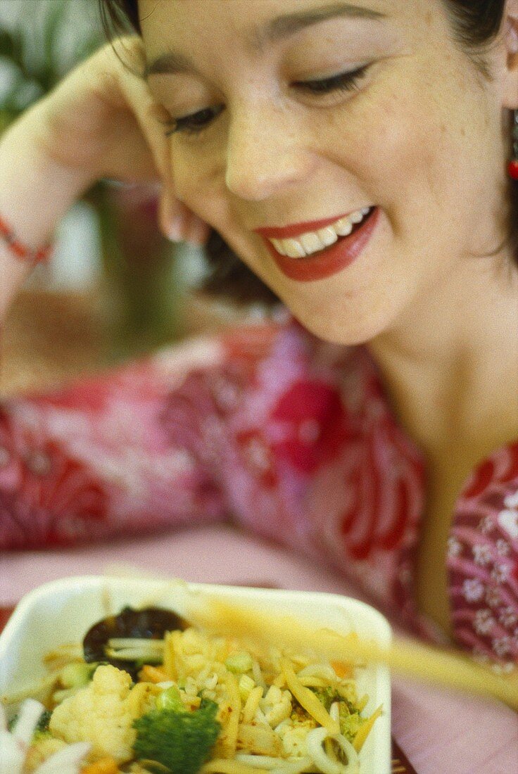 Frau isst asiatisches Gemüsegericht