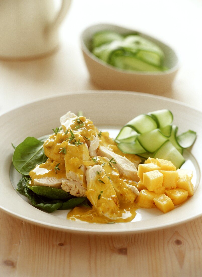 Chicken breast with curry sauce, mango and cucumber salad