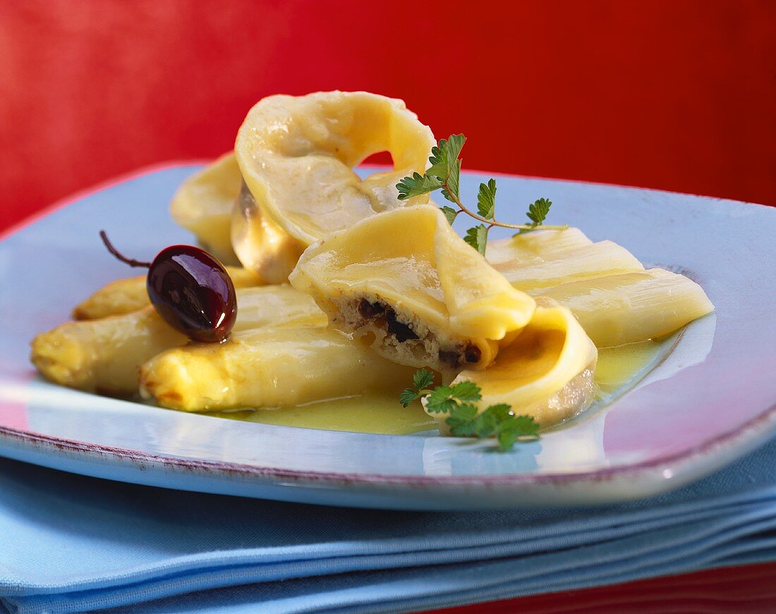 Ravioli mit Olivenfüllung auf weißem Spargel