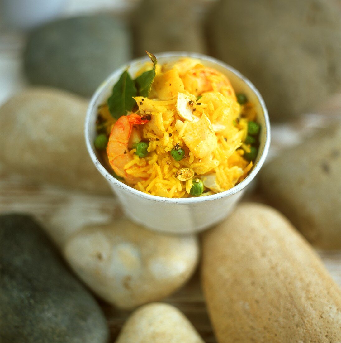 Curried rice with fish and shrimps in small bowl