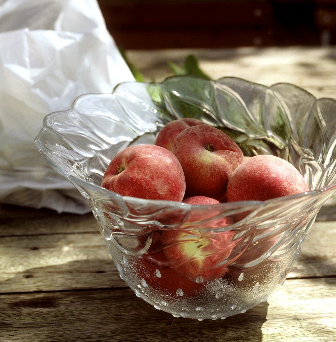 Fresh peaches in glass bowl