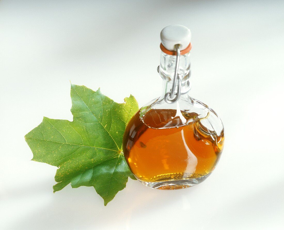 Bottle of maple syrup and maple leaf