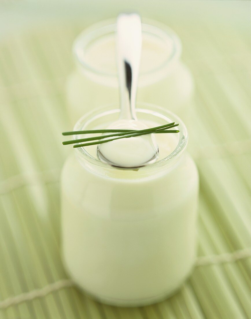 Yoghurt in jar and on spoon with chives