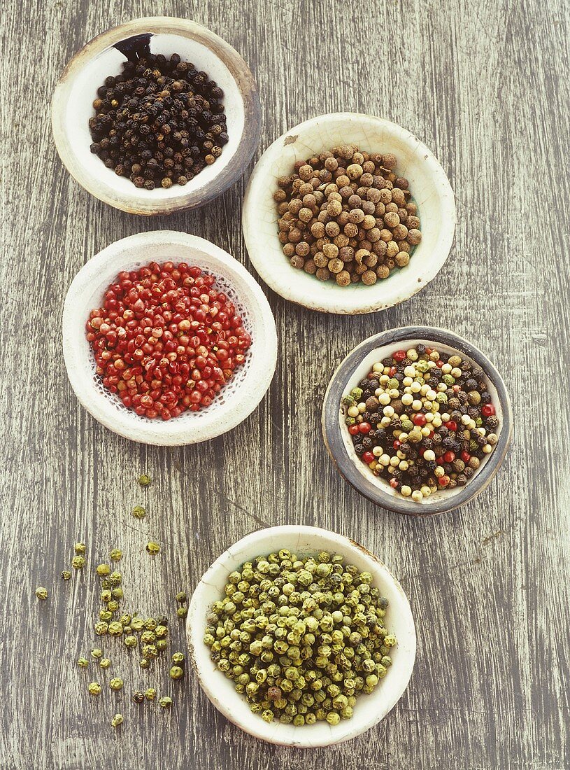 Various kinds of peppercorns in bowls