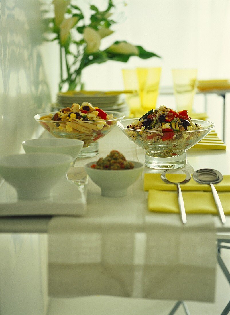 Pasta salad and rice salad on laid table