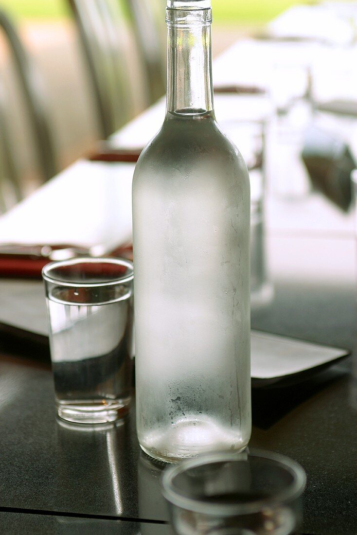 Wasser in Flasche und Gläsern auf Esstisch