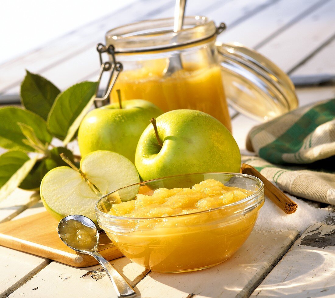 Apple compote in bowl and jar; fresh green apples