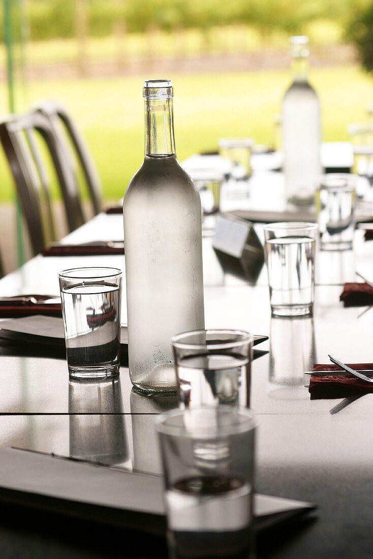 Laid table with water bottles and glasses