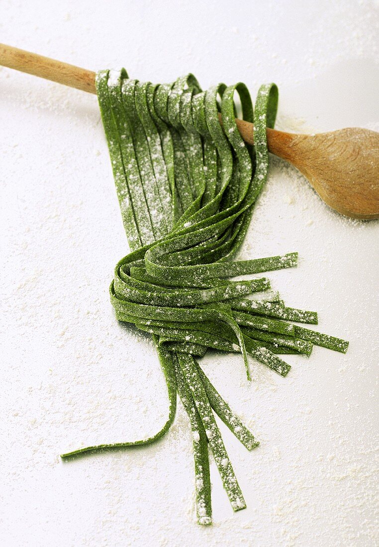 Home-made green ribbon pasta on kitchen spoon