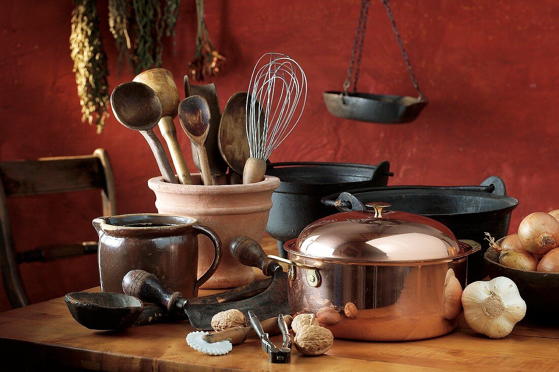 Pans, utensils, vegetables and nuts in rustic kitchen