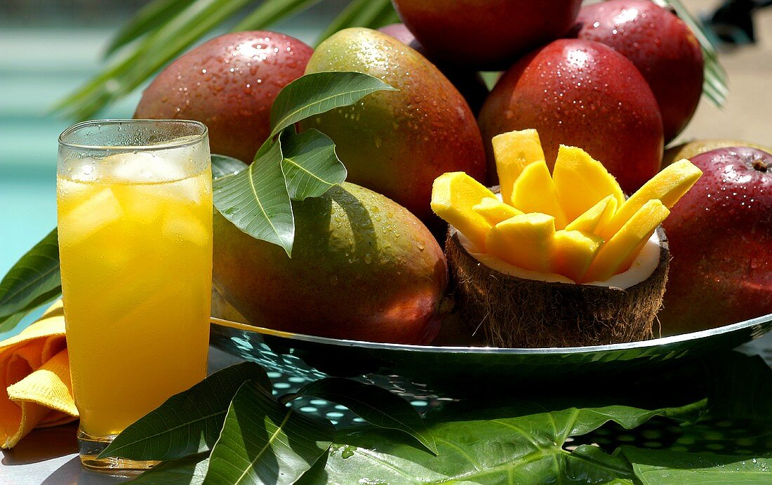 Fresh mangoes, slice of mango and glass of mango juice