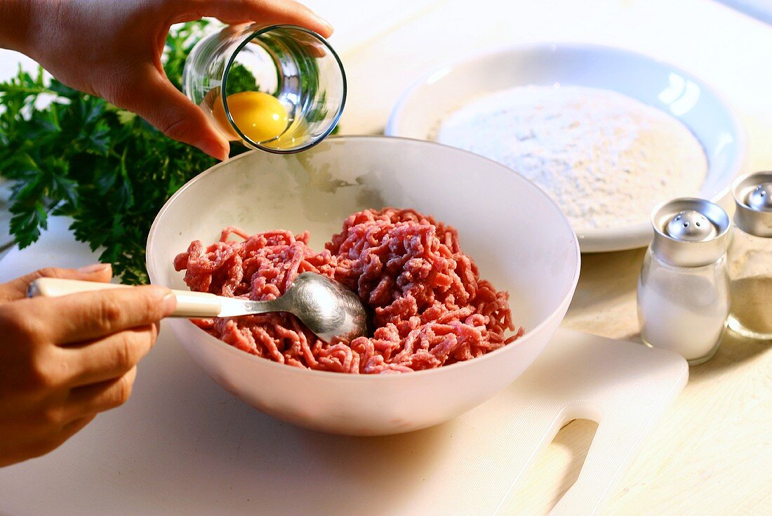 Making rissoles: adding egg