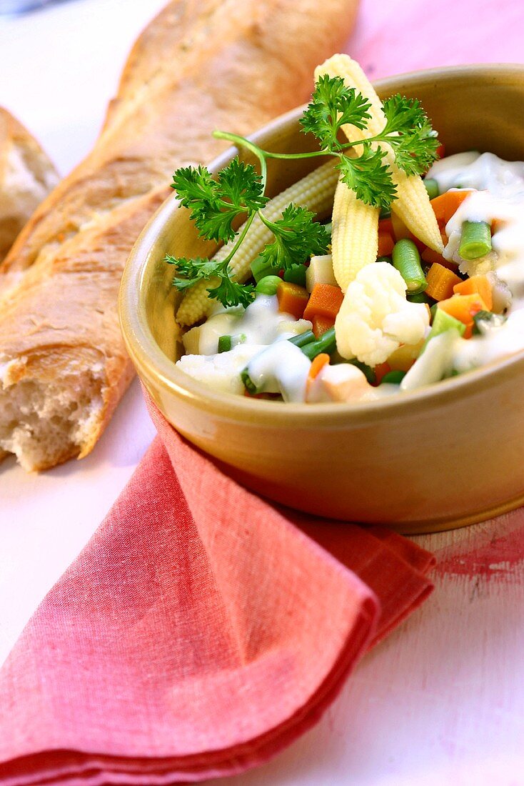 Vegetables with cheese sauce; baguette
