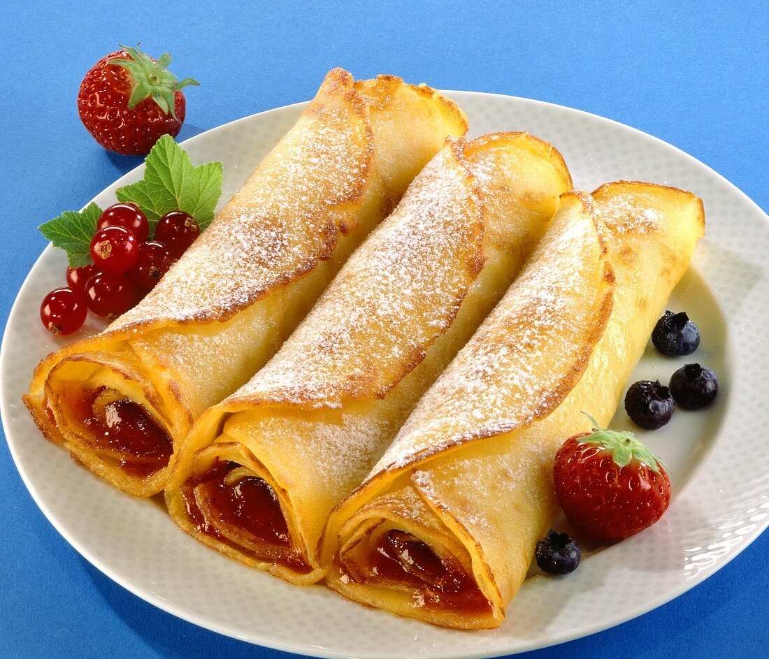 Crepes with berry jam and icing sugar