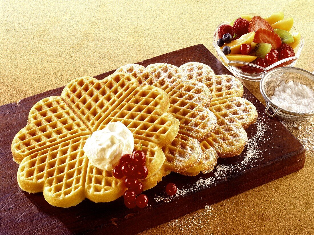 Waffles with icing sugar, cream and fruit