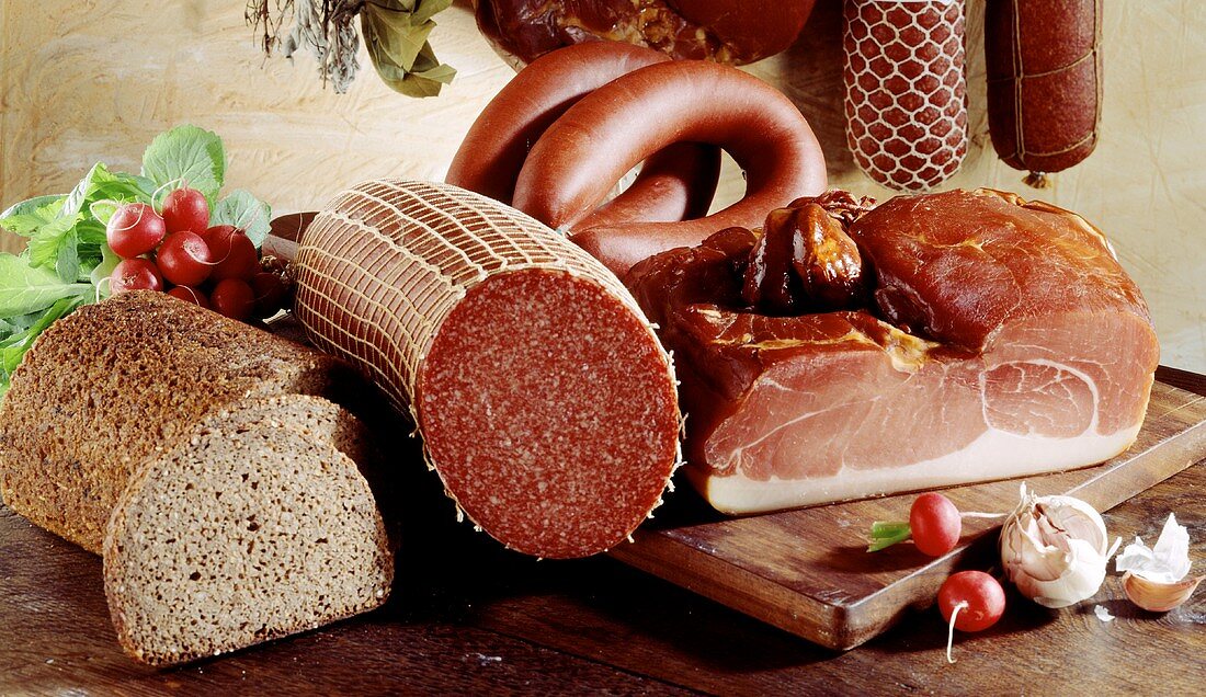 Various types of sausages, bread and radishes