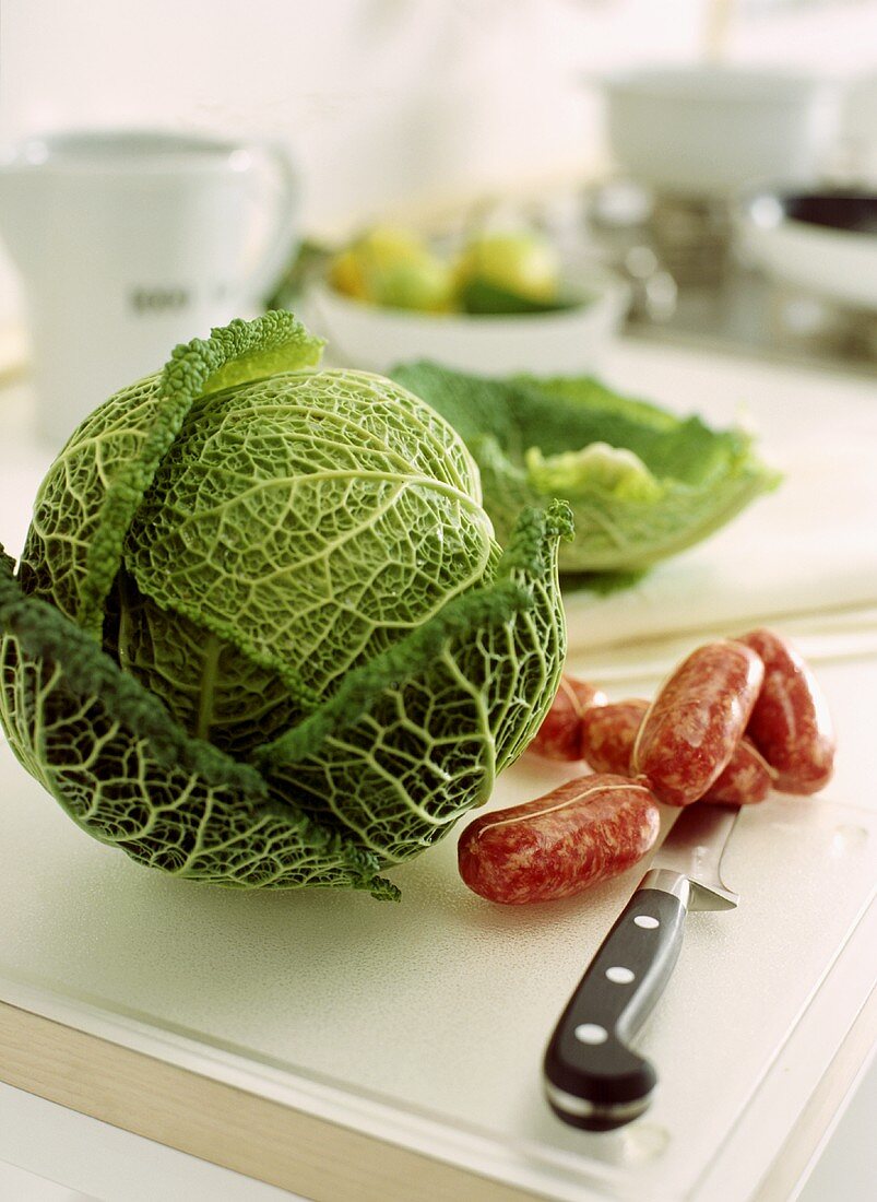 Fresh savoy and sausages in kitchen