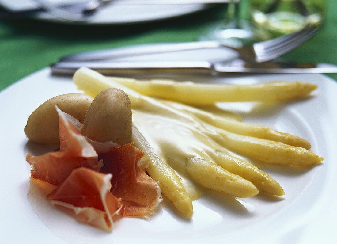 Asparagus with hollandaise sauce, raw ham and potatoes