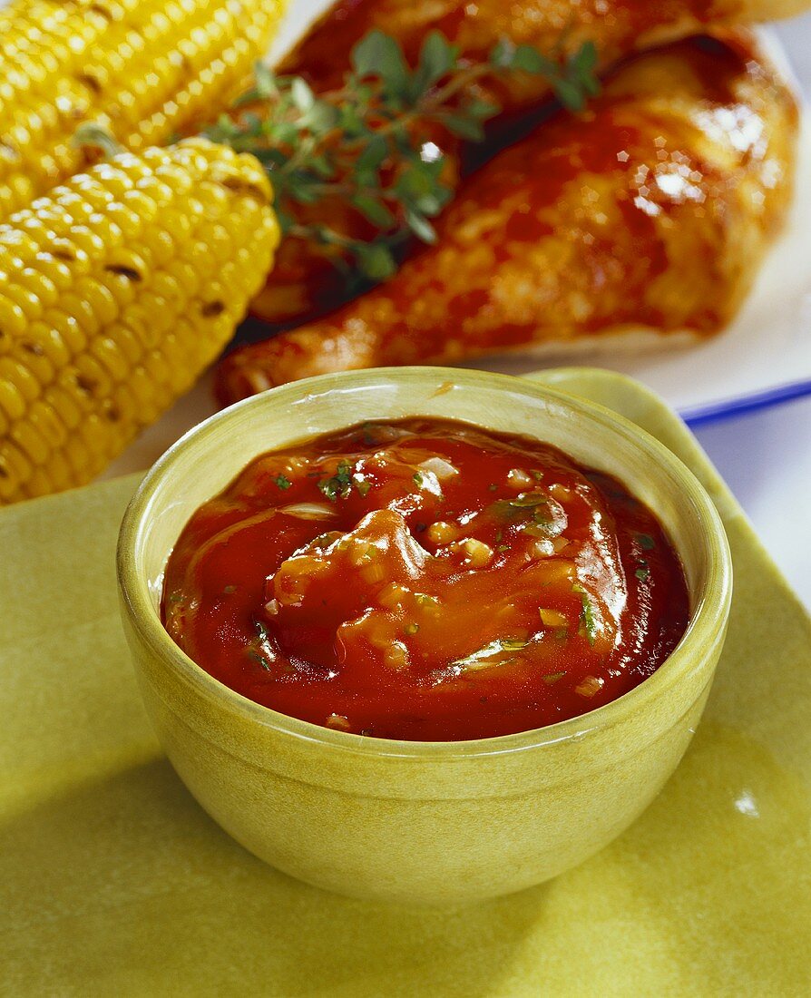 Barbecue sauce; barbecued chicken legs and corncobs