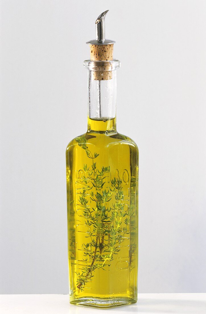 A bottle of olive oil with thyme