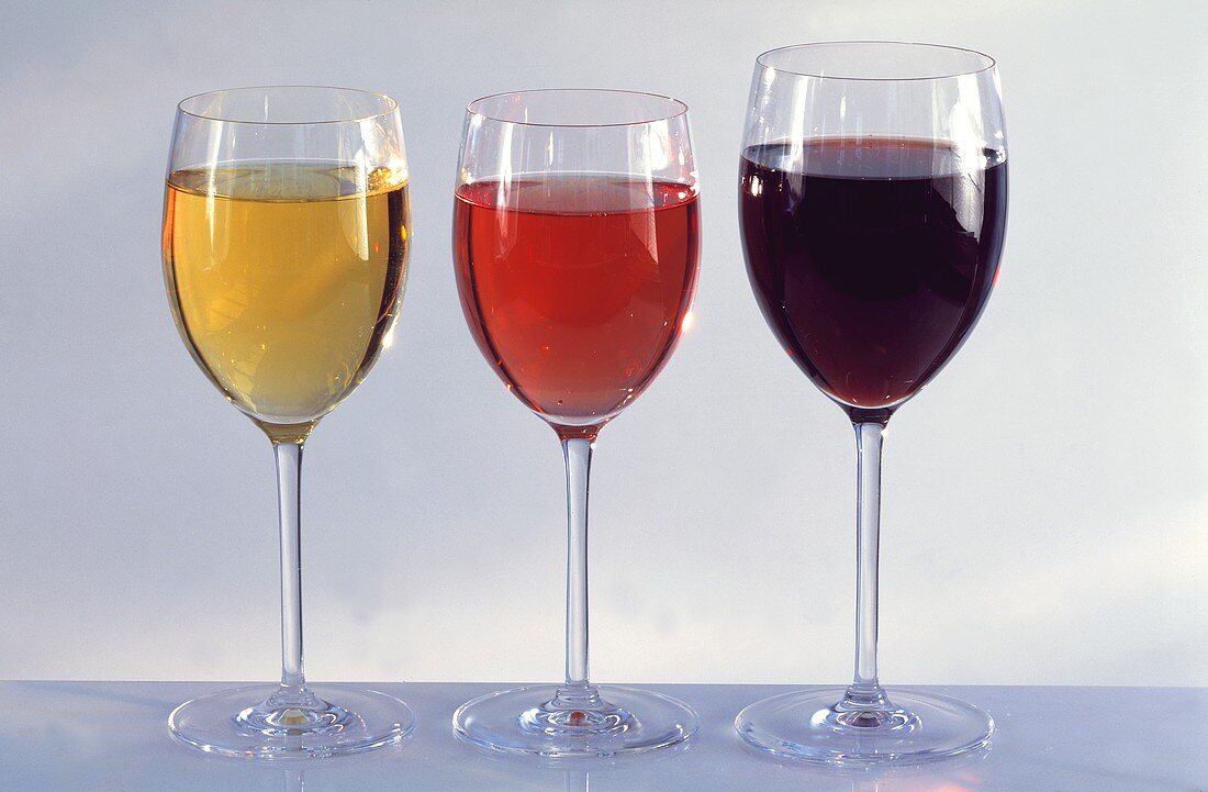 A glass of red wine, rose wine and white wine
