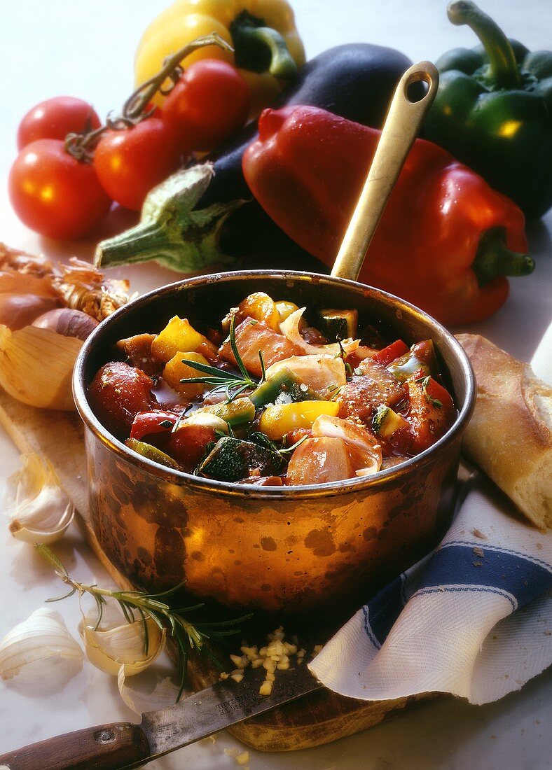 Ratatouille in pan, fresh vegetables all around