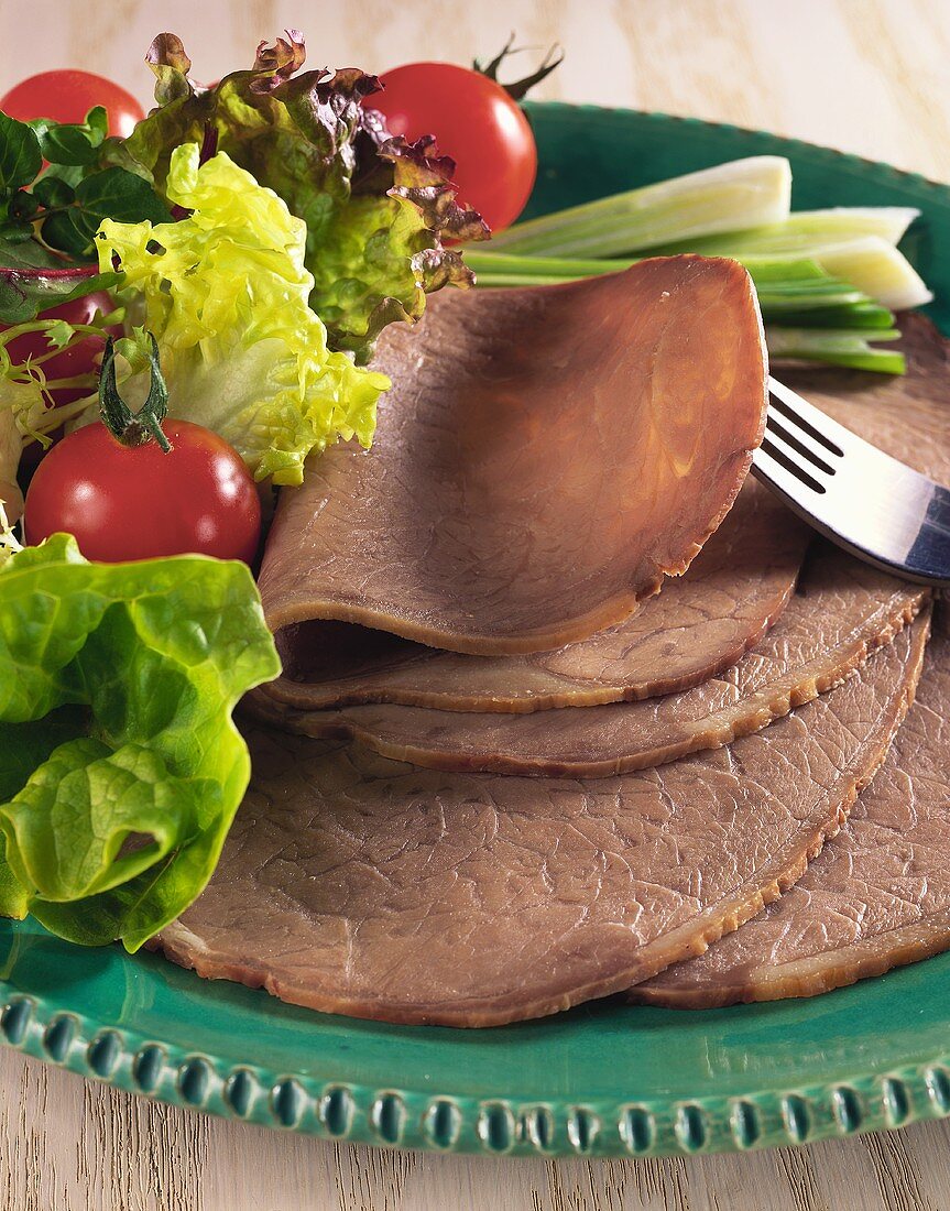 Sliced boiled beef with salad on plate