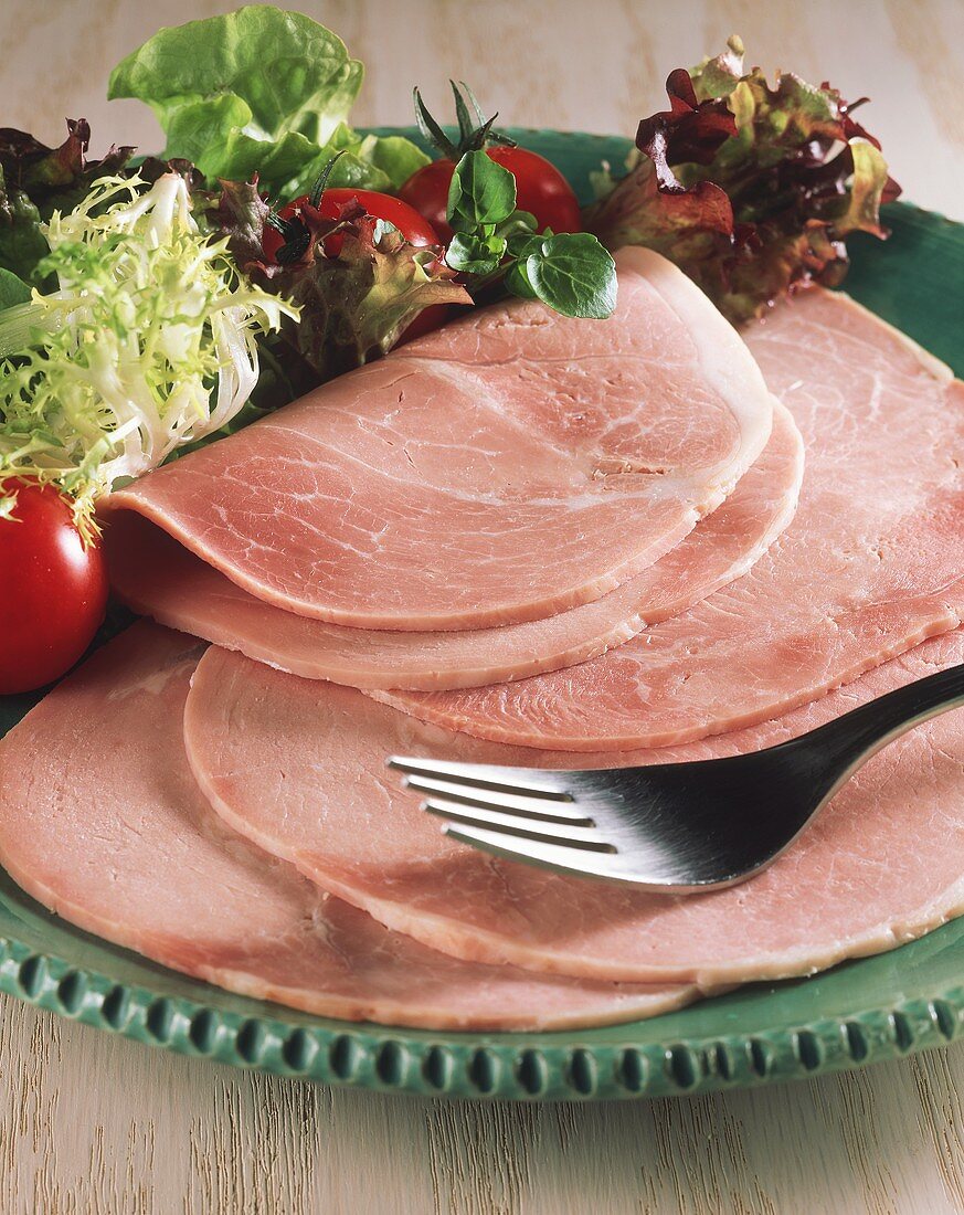 Aufgeschnittener Kochschinken mit Salat auf Teller