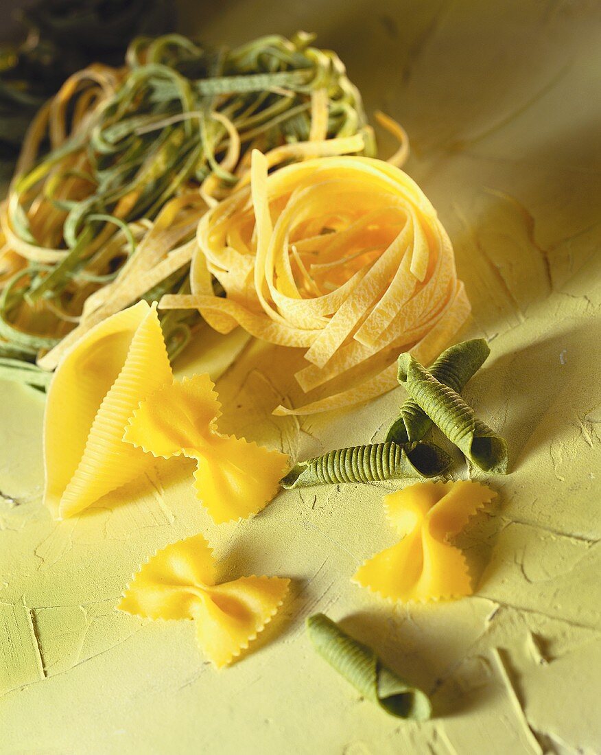 Yellow and green pasta on green background