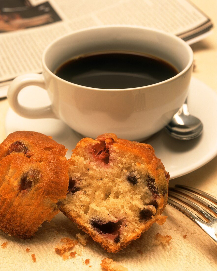 Eine Tasse Kaffee mit geteiltem Muffin