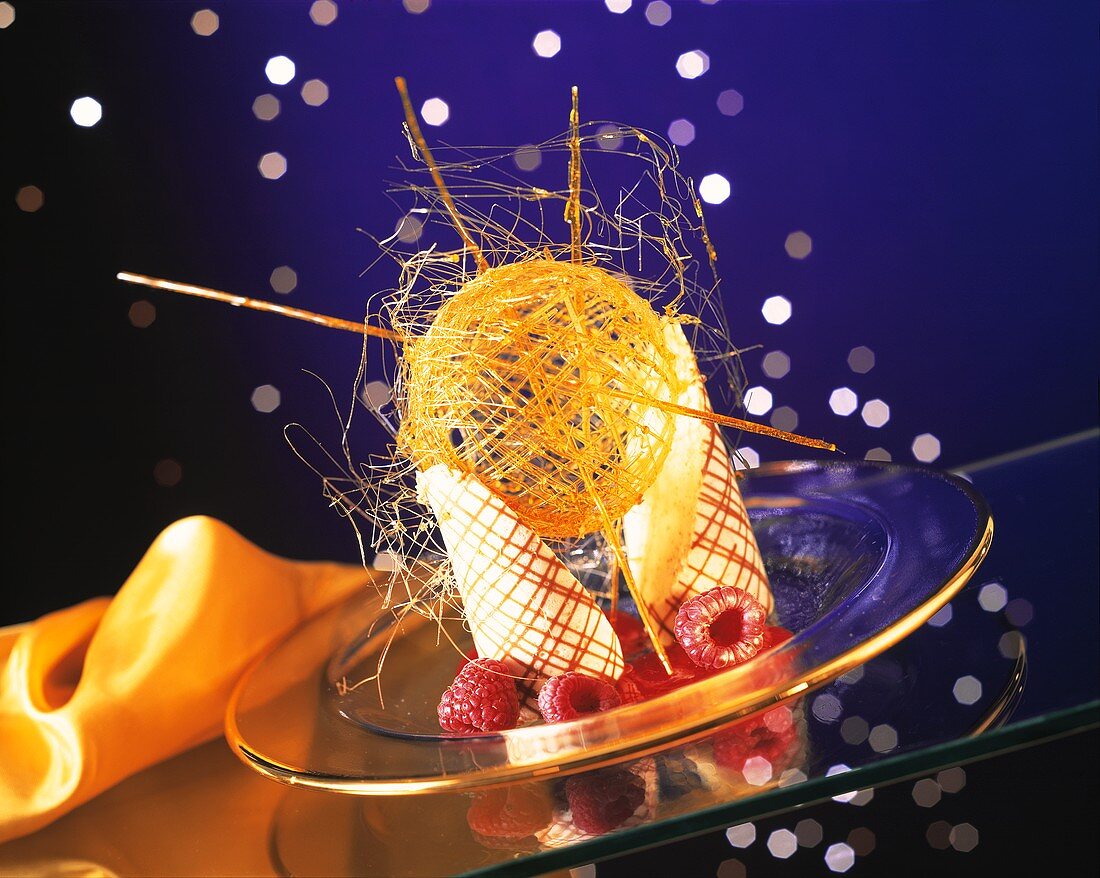Around the world: curved wafers with a ball of spun caramel and raspberries