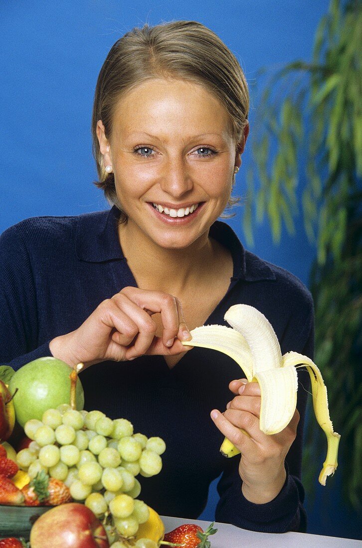 Frau schält eine Banane