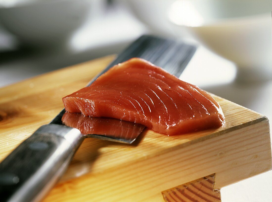 Eine Scheibe Thunfisch auf einem Messer (für Sushi)