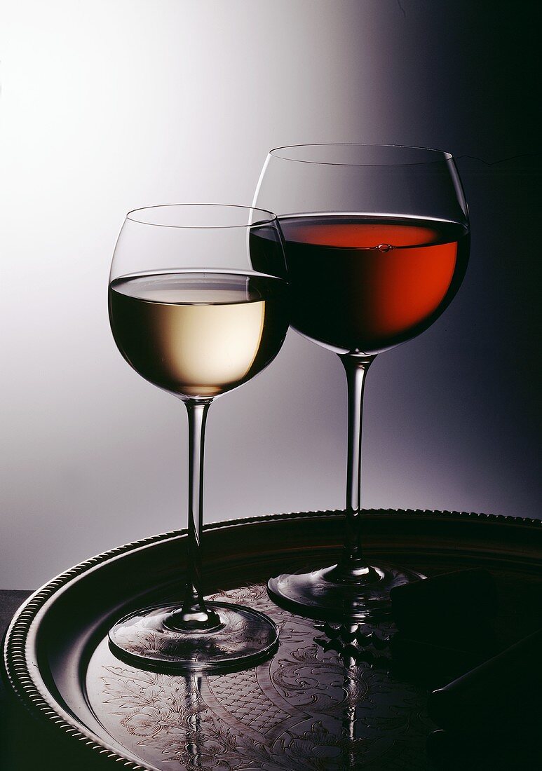 Ein Glas Weißwein und ein Glas Rotwein auf Silbertablett