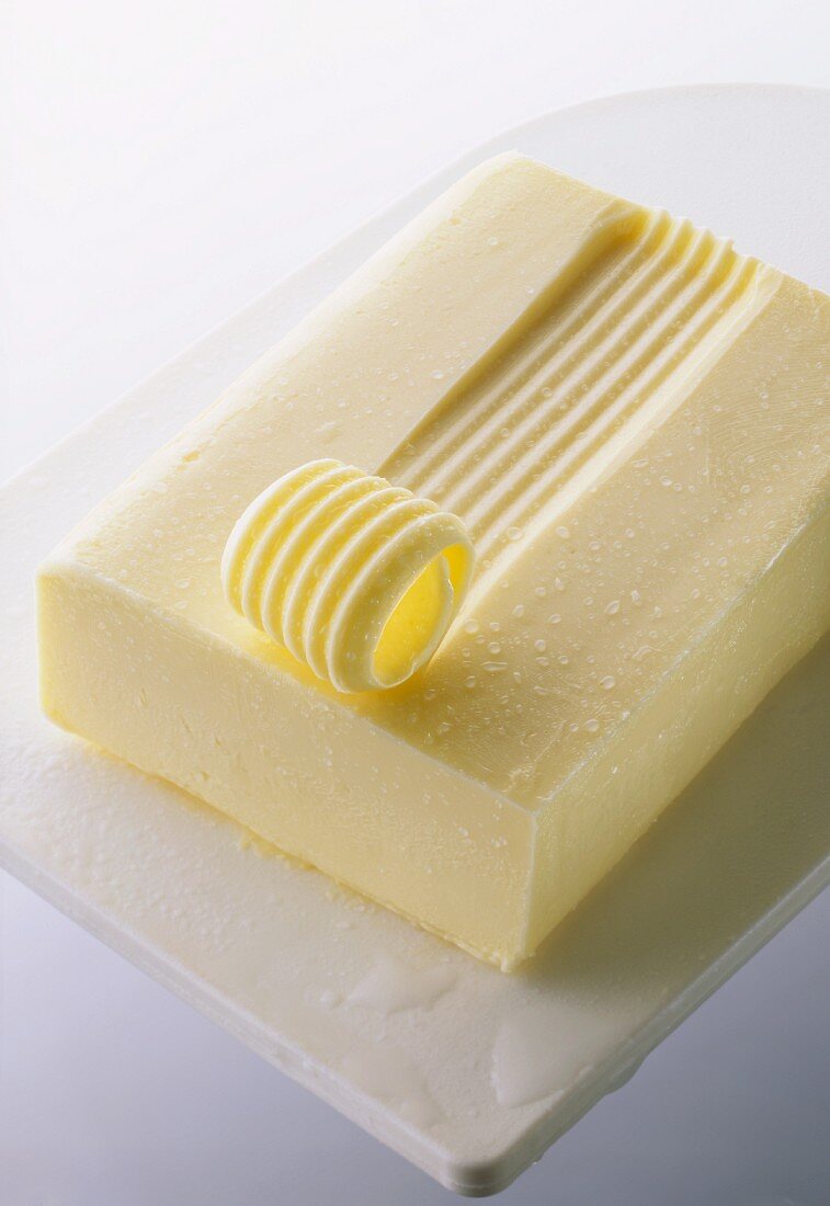 Ein Stück Butter mit Butterröllchen