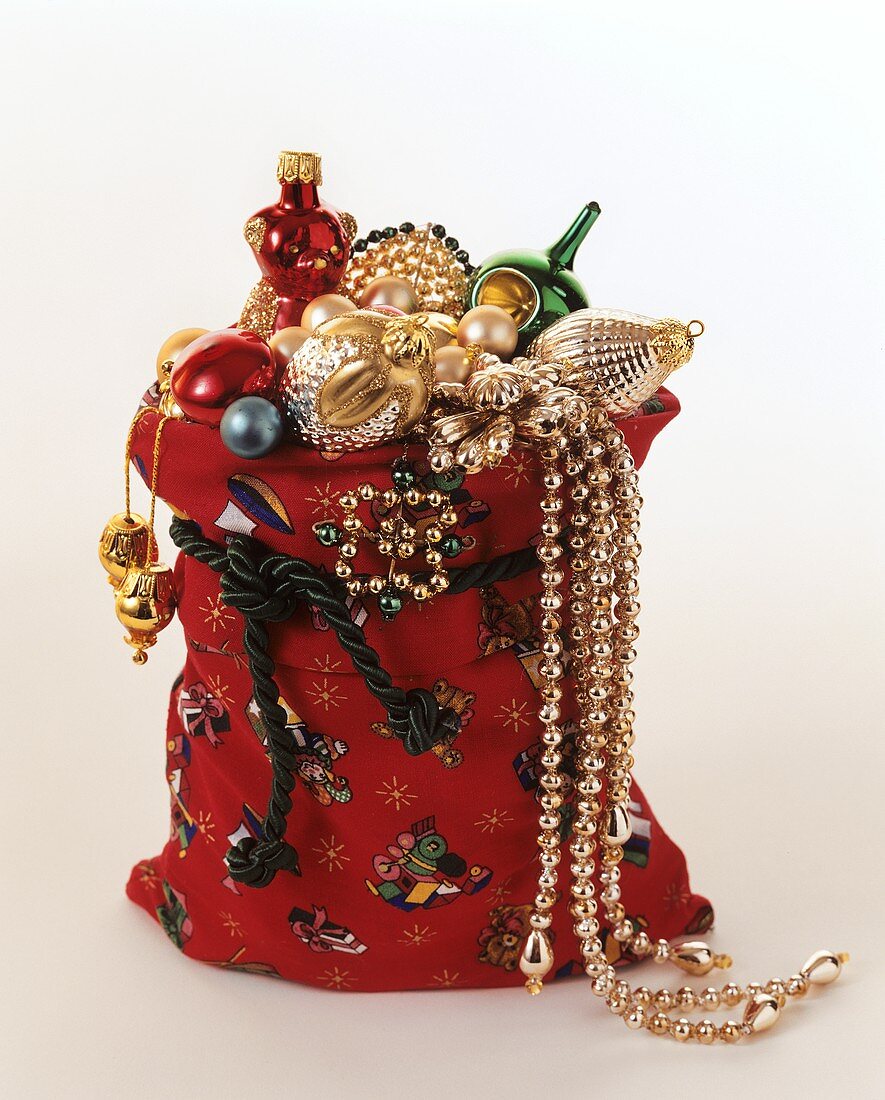 Christmas baubles and gold chains in red sack