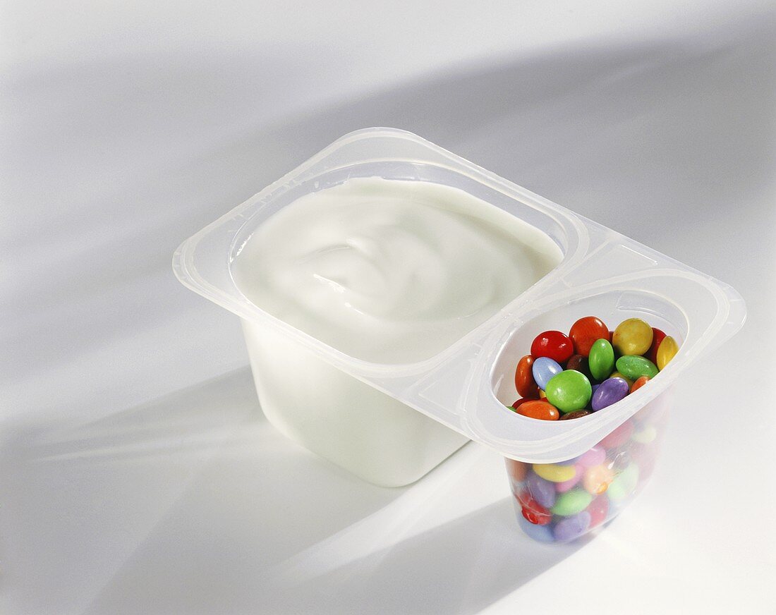 Yoghurt with coloured chocolate beans in pot 