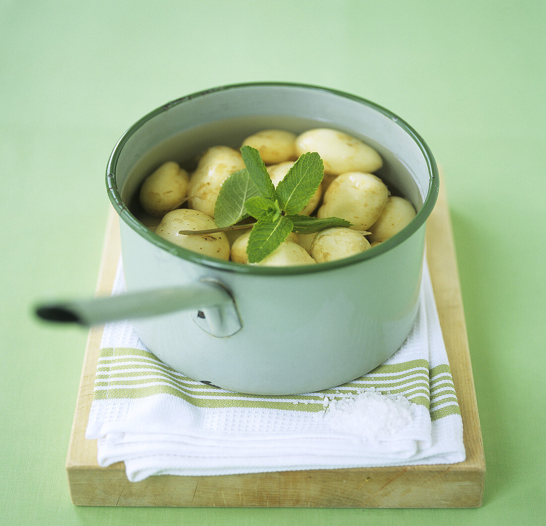 Cooked potatoes in pan on chopping board
