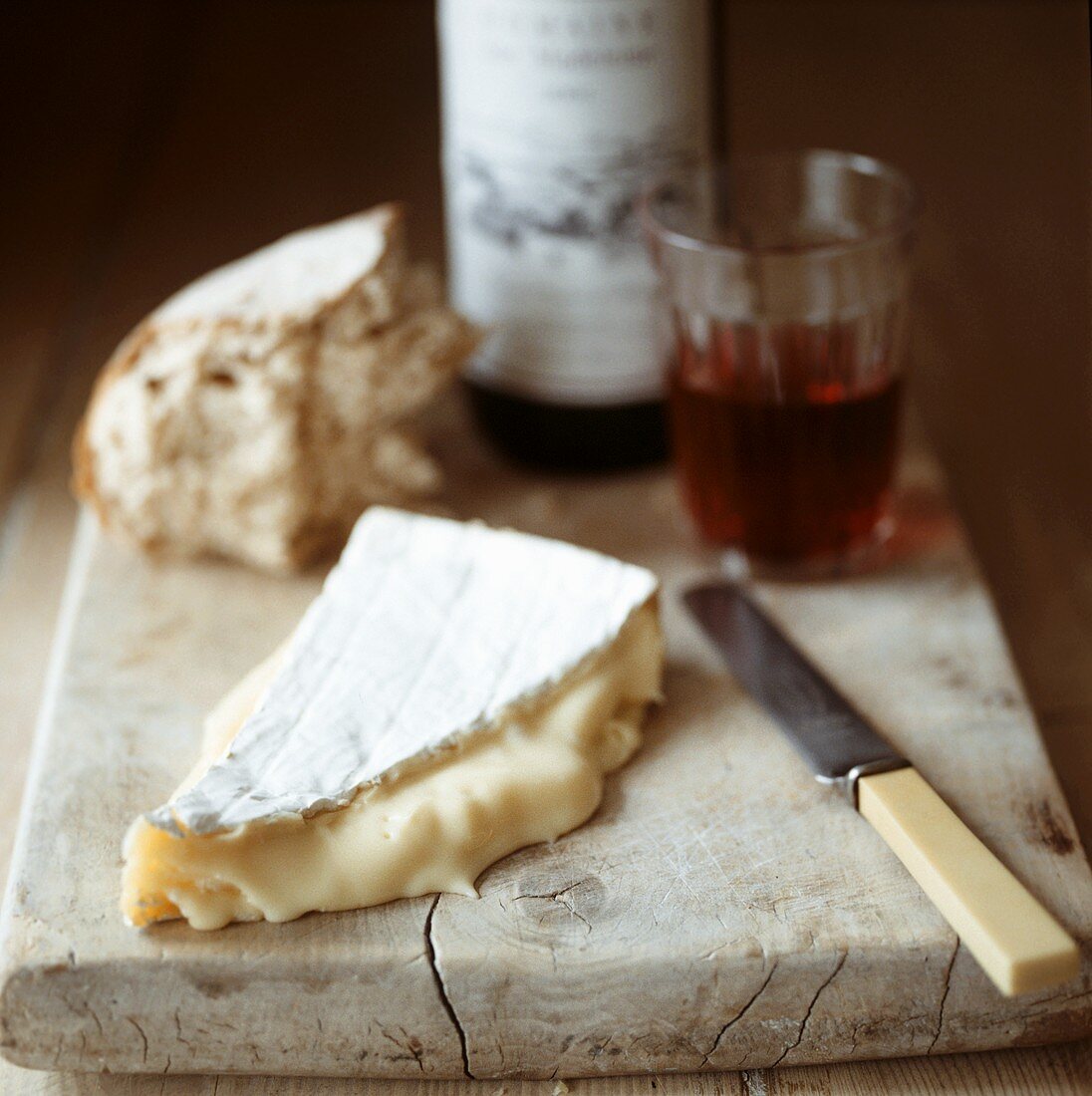 Piece of Brie, bread and red wine