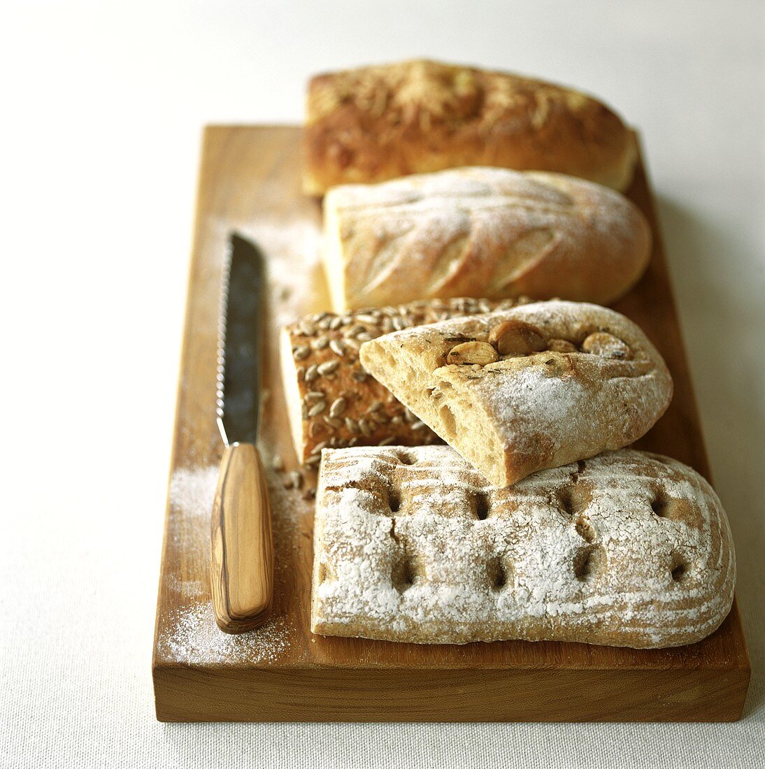 Assorted loaves on wooden chopping board