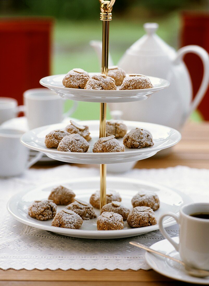 Almond biscuits with icing sugar on tiered stand in open air