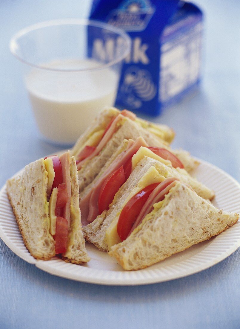 Schinken-Käse-Sandwiches und Glas Milch