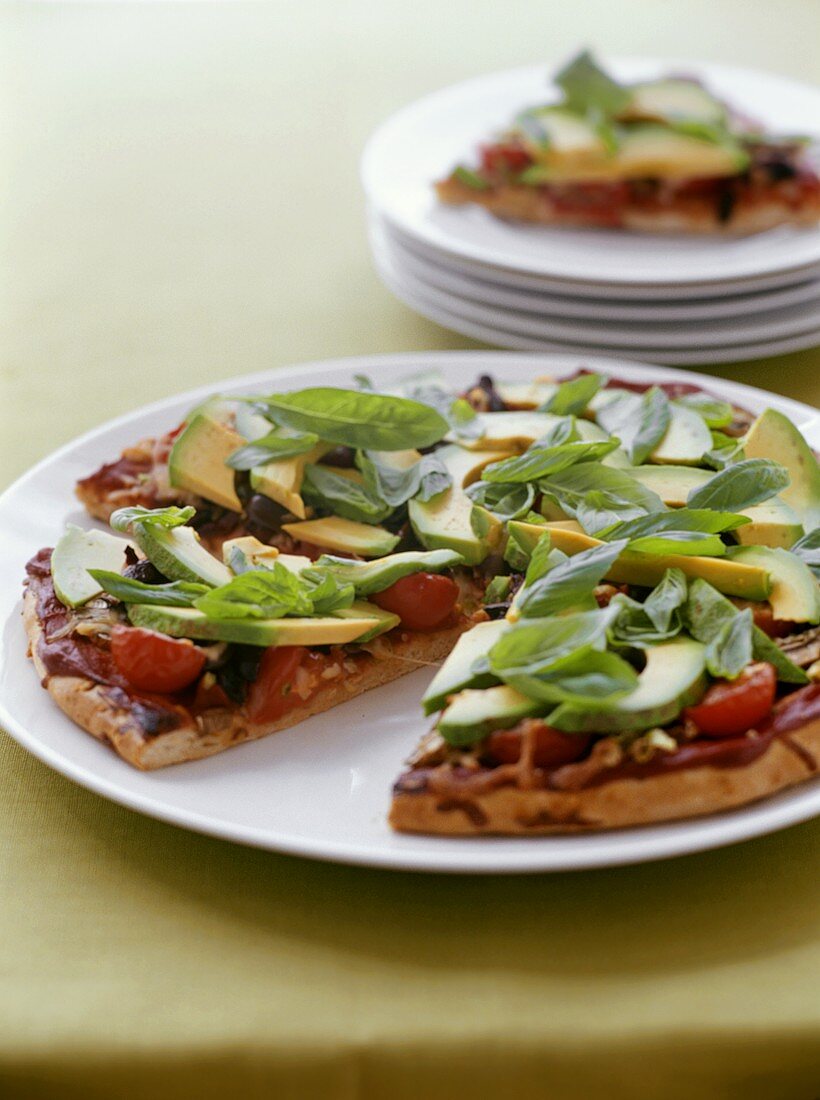 Pizza mit Avocado, Tomaten und Basilikum