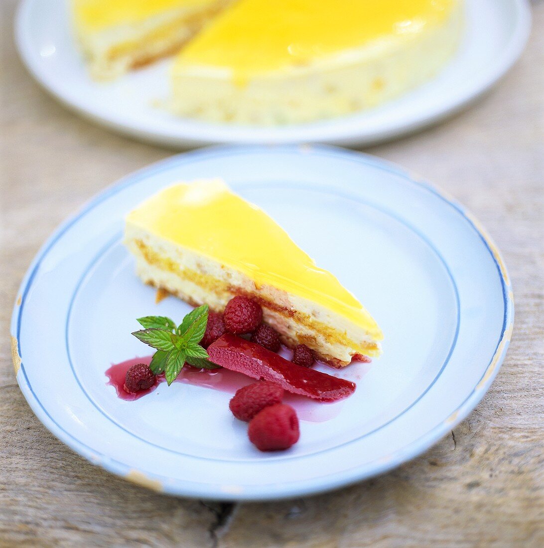 Ein Stück Zitronen-Sahne-Torte mit Himbeersauce