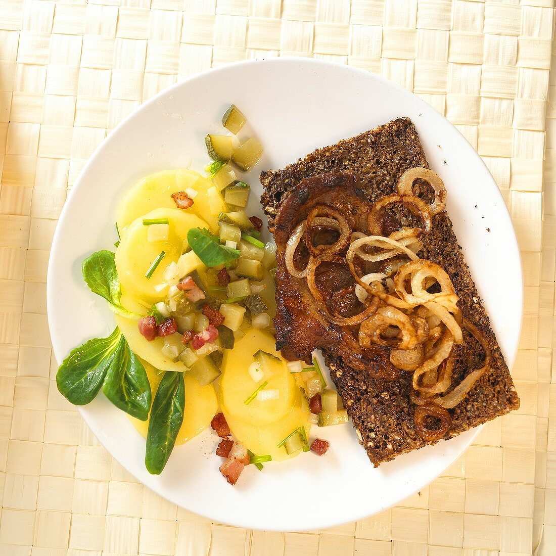 Steak with onions on bread; potato salad