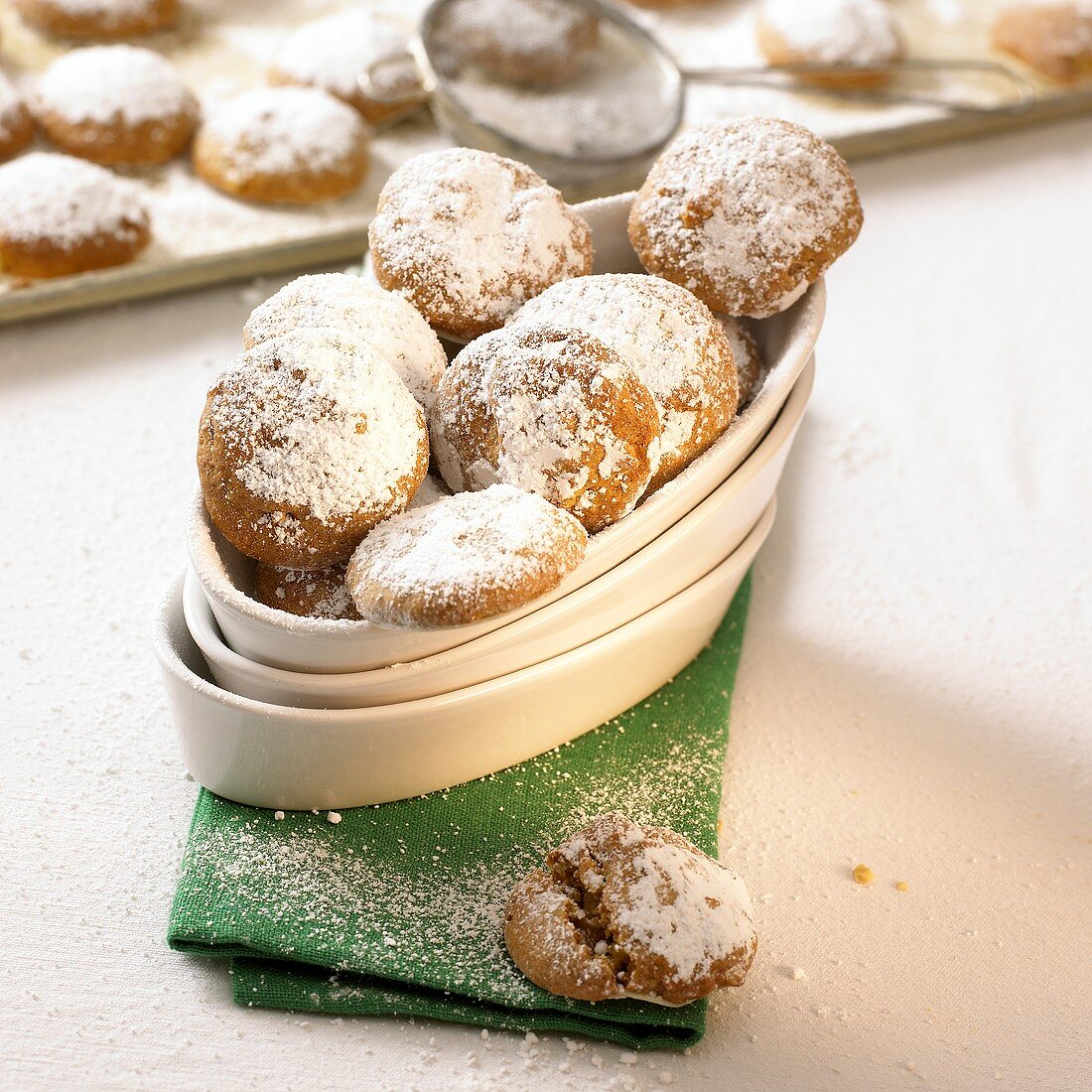 Gingerbread biscuits with icing sugar in white bowl