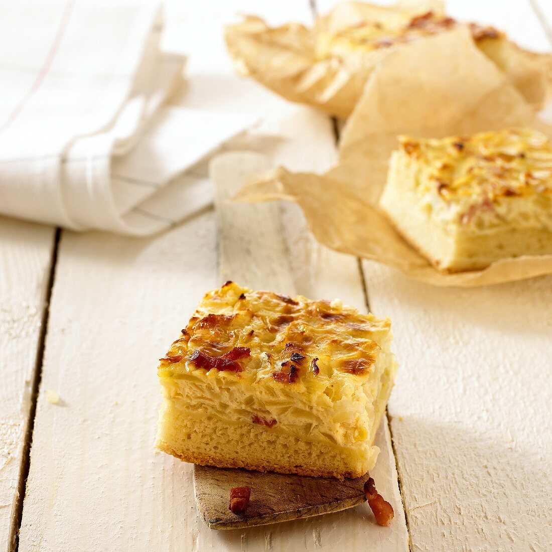 Zwiebelkuchen mit Speck auf Heber und Papier