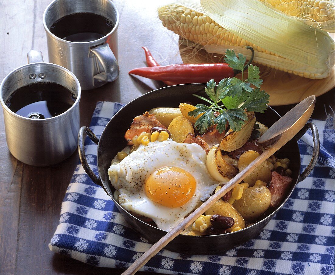 Pan-cooked potato and vegetable dish with fried egg