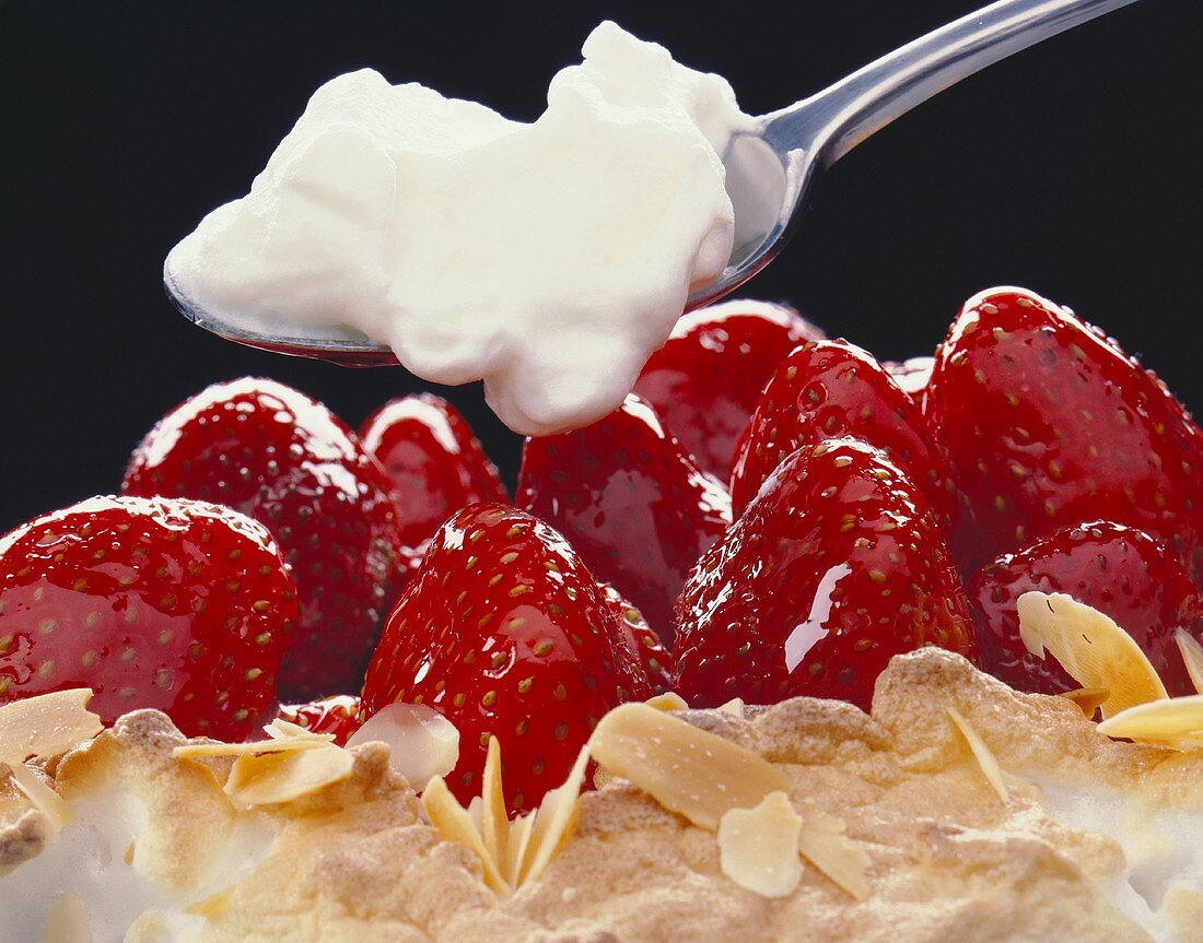 Erdbeer-Baiser-Kuchen, darüber Löffel mit Eischnee